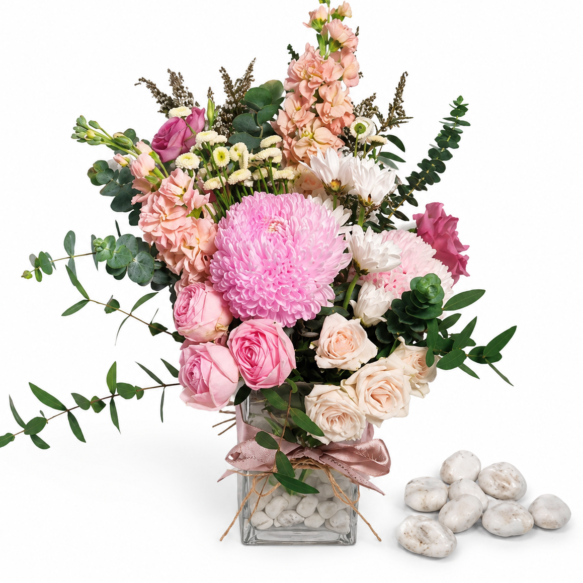 Bouquet of pink and white flowers in a clear vase on a white background