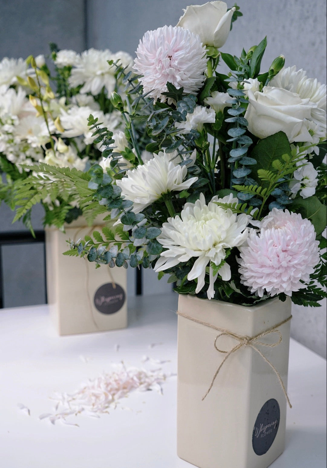 Floral arrangements in decorative boxes on a light surface with a neutral background