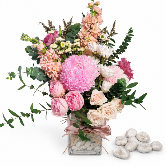 Bouquet of pink and white flowers in a clear vase on a white background