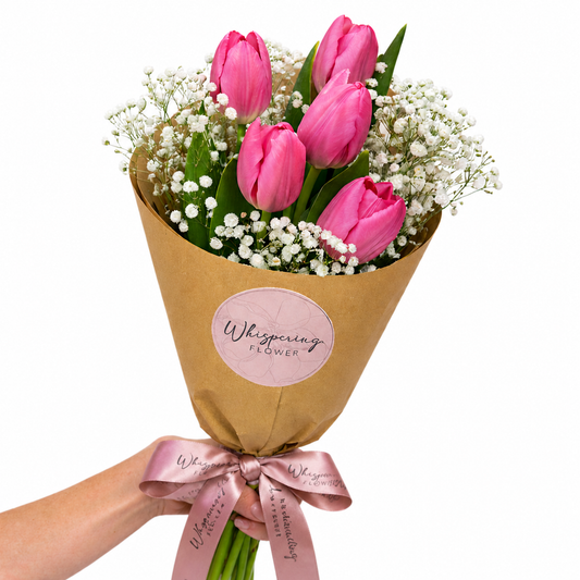 Bouquet of pink tulips wrapped in brown paper with a pink ribbon and 'Whispering Flower' label.