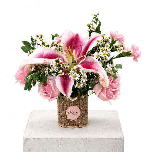 Mum's Little Garden bouquet — stargazer lilies, pink gerberas, white roses, and seasonal blooms hand-arranged in a kraft container. Mother's Day Auckland delivery.