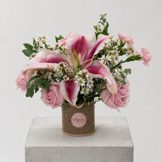 Mum's Little Garden bouquet — stargazer lilies, pink gerberas, white roses, and seasonal blooms hand-arranged in a kraft container. Mother's Day Auckland delivery.